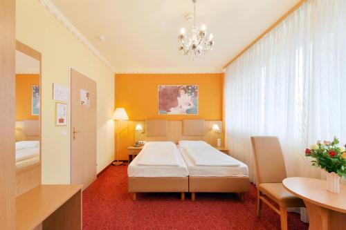 维也纳Garten- und Kunsthotel Gabriel City的酒店客房配有一张床铺和一张桌子。