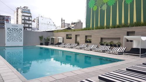 布宜诺斯艾利斯GrandView Hotel Buenos Aires的大楼内带躺椅的大型游泳池