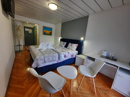 梅德沃代格斯提赛兹洛住宿加早餐旅馆的一间卧室配有一张床和两把白色椅子