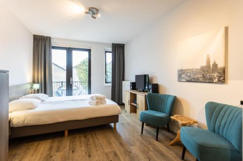 乌得勒支乌特勒支城市公寓 - 维尔德辛格的一间卧室配有一张床和两张蓝色椅子