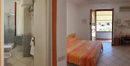 圣安德烈亚Villa dei Limoni的一间卧室配有一张床,浴室设有淋浴。