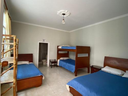 圣弗朗西斯科Hotel Nueva Ardenza的一间卧室配有两张床和一张双层床。
