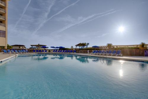 来特斯维比奇Holiday Inn Resort Lumina on Wrightsville Beach, an IHG Hotel的度假村内带蓝色椅子的大型游泳池