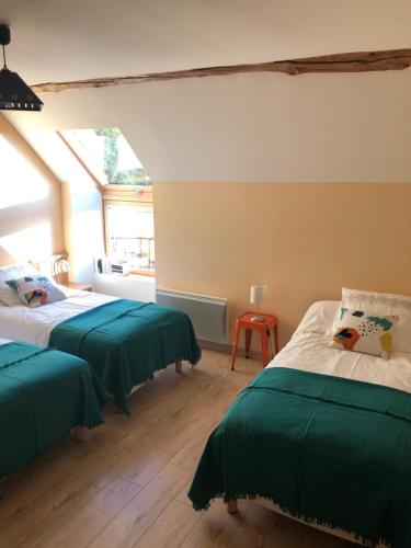 Saint-Hilaire-de-GondillyGîte La Ferranderie的一间卧室配有两张带绿床单的床