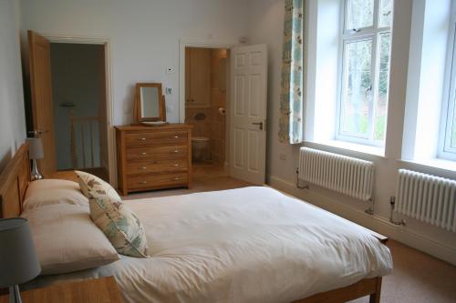 尚克林Shanklin Manor的一间卧室配有一张床、一个梳妆台和一扇窗户。