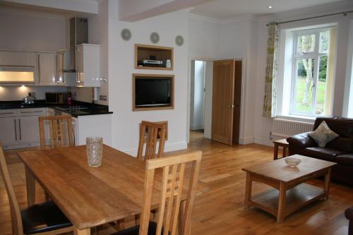 尚克林Shanklin Manor的厨房以及带木桌和椅子的客厅。
