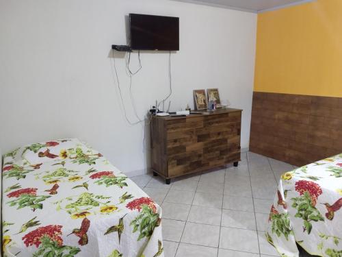 卡瓦坎特Pouso do Beija-Flor的客房设有两张床和一台墙上的电视