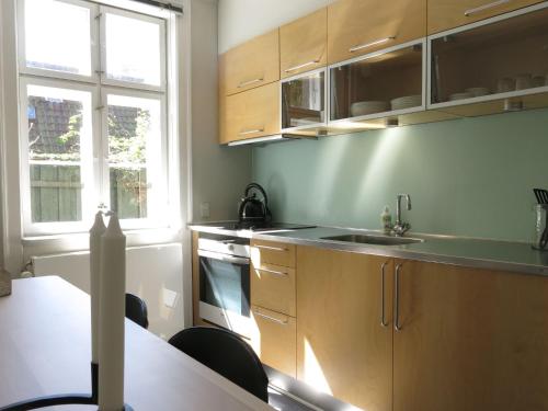 哥本哈根ApartmentInCopenhagen Apartment 1141的厨房配有木制橱柜、水槽和桌子