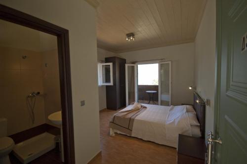 阿约斯尼奇塔斯莱夫卡斯佩特拉旅馆的一间卧室配有一张床,浴室设有水槽