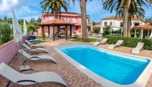 阿祖罗港罗莎别墅酒店的一个带躺椅的游泳池以及一座房子