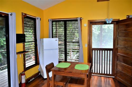 圣伊格纳西奥Sanpopo Tree Top Cottage - A Gold Standard Tourism Approved Vacation Home的厨房配有桌子和白色冰箱。