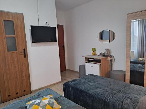 米耶伦科Villa Monica pokoje dwuosobowe tylko dla dorosłych的卧室配有一张床,墙上配有电视。