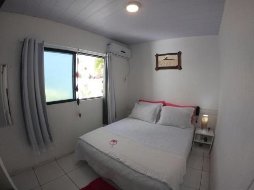 纳塔尔美利加多索旅馆的一间小卧室,配有床和窗户