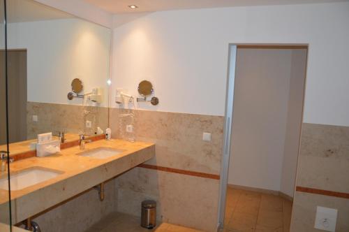施洛斯霍尔特-斯图肯布罗克Hotel Holter Schloßkrug的浴室设有2个水槽和镜子