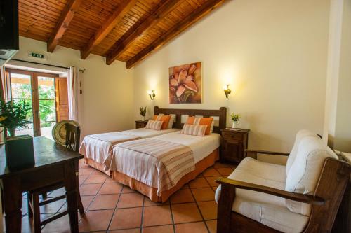 奥德赛克斯Monte Joao Roupeiro - Turismo Rural的一间卧室配有两张床和一张桌子及椅子