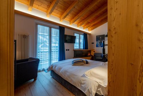 马代西莫阿尔皮娜体育酒店的一间卧室设有一张大床和两个窗户。