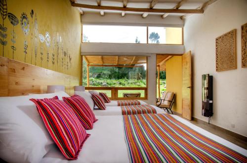 Yanque齐拉瓦斯山林小屋的卧室配有一张带彩色枕头的大型白色床。