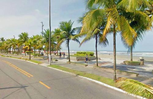 大普拉亚Apartamento aconchegante 1 quadra da praia的海滩上一条种有棕榈树的街道