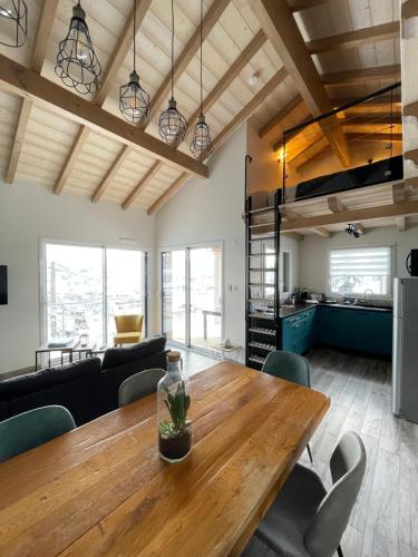 热拉梅le bleu du lac Sauna et Spa的用餐室和带木桌的客厅