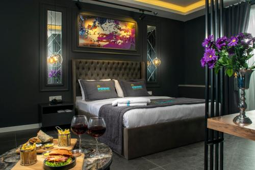 伊斯坦布尔La Cielo Hotel Bostancı的一间卧室配有一张床和两杯葡萄酒