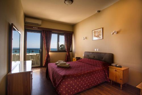 利马索尔雄鸽海滩公寓酒店的一间卧室设有一张床和一个大窗户