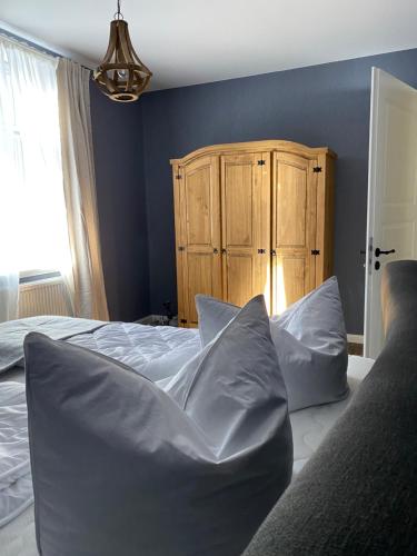 韦尼格罗德Auszeit-Appartement Wernigerode的一间卧室配有带枕头的床铺和木制橱柜