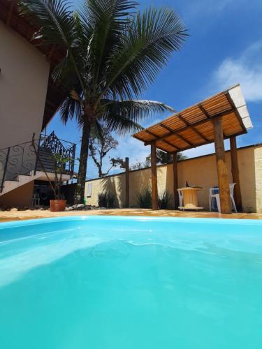 乌巴图巴Suítes Canola的棕榈树屋前的游泳池