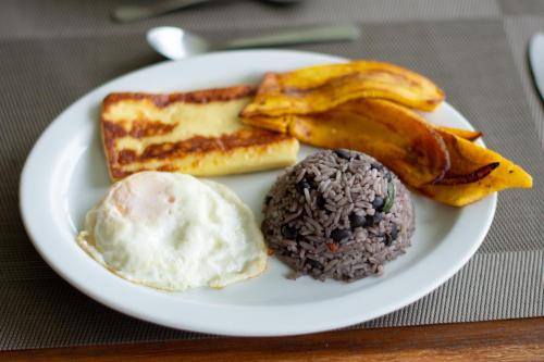 蒙泰韦尔德哥斯达黎加卡比纳斯艾迪住宿加早餐旅馆的包括鸡蛋面包和香蕉的早餐食品