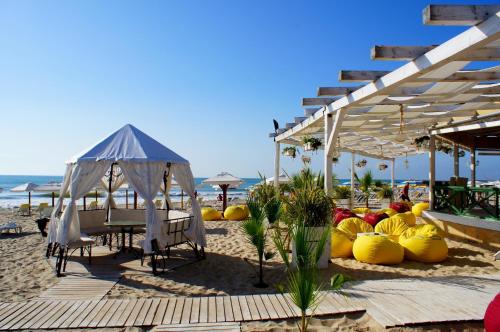 克兰内沃朱利安家庭酒店的海滩上配有桌椅和帐篷