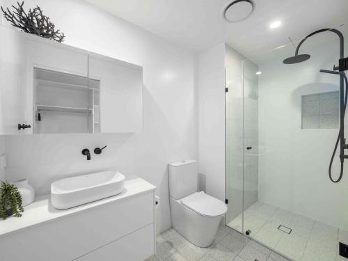 科夫斯港太平洋滨海公寓式酒店的白色的浴室设有卫生间和淋浴。