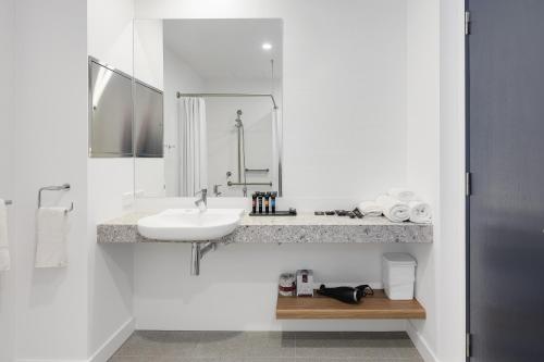 纽卡斯尔Springs Newcastle的白色的浴室设有水槽和镜子