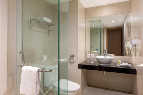棉兰Swiss-Belinn Gajah Mada Medan的浴室配有卫生间、盥洗盆和淋浴。