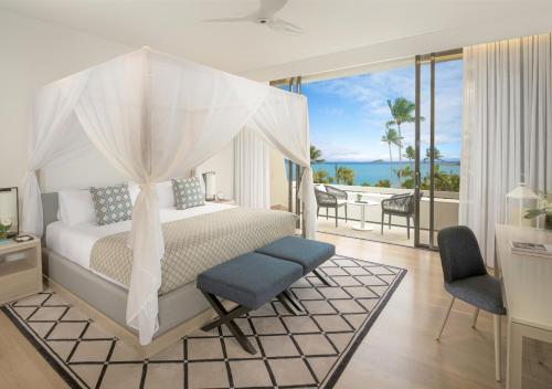 海曼岛InterContinental Hayman Island Resort, an IHG Hotel的一间卧室设有一张床和一个海景阳台