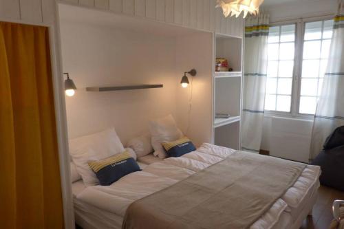 雷岛林滩MAISON 120m2 près centre et plages classée ***的一间卧室配有一张大床和两个枕头