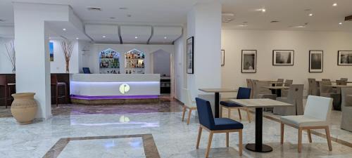 塞维利亚帕萨雷拉酒店的一间带桌椅和柜台的餐厅