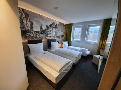 韦特海姆Euro Hotel Wertheim的酒店客房设有两张床,墙上挂有绘画作品
