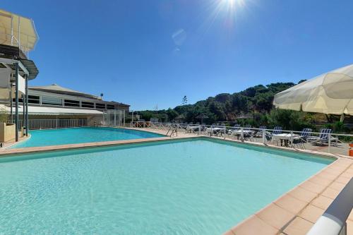 格吕桑Hotel Le Phoebus Garden & Spa的一个带椅子和遮阳伞的大型游泳池