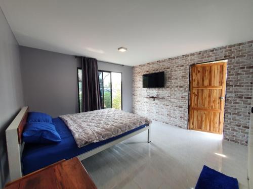 Ban Khao Khayai (1)สกายวิวรีสอร์ท ชัยนาท的一间卧室设有一张床和砖墙