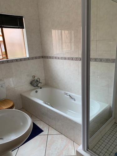 博克斯堡Celtis Lane Guest House的带浴缸和盥洗盆的浴室