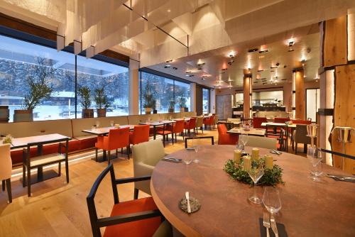 派克波特斯耐兹库Grand Hotel Hradec的餐厅设有桌椅和大窗户。