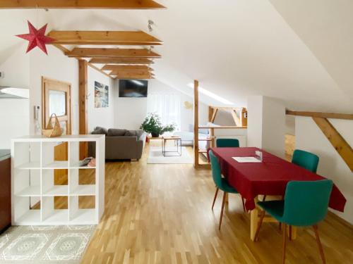 Kolonie RöntgentalSchwanenburg Apartments的客厅配有红色桌子和绿色椅子