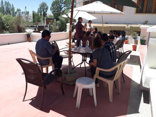 列城Smanla guest house的一群人坐在庭院的桌子旁