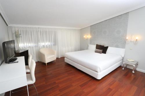 罗德里戈城Hotel Conde Rodrigo 2的酒店客房设有白色的床和电视。
