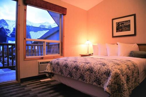 坎莫尔MountainView -PrivateChalet Sleep7- 5min to DT Vacation Home的一间卧室设有一张床和一个大窗户