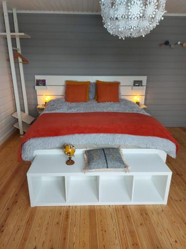 特镇Aux Capucines的一间卧室配有一张带红色毯子的大床