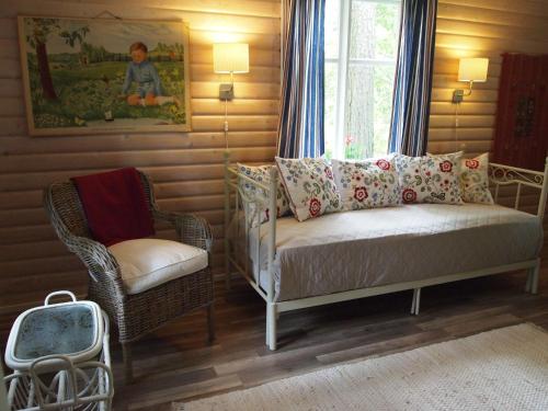 纳坦利Tammiston Cottages的卧室配有床、椅子和窗户。