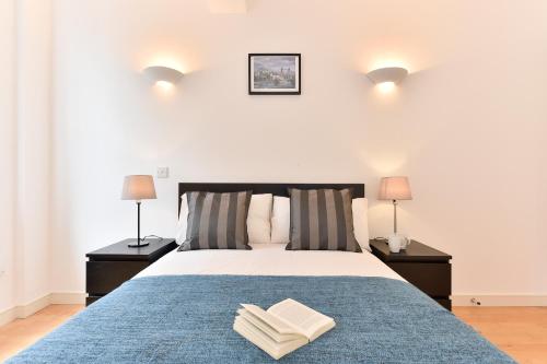 伦敦Shoreditch Vibe Apartments的一间卧室配有一张带两盏灯和两条毛巾的床。