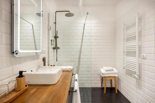 伊瓜拉达Cal Roure Boutique Hotel的白色的浴室设有浴缸和水槽。