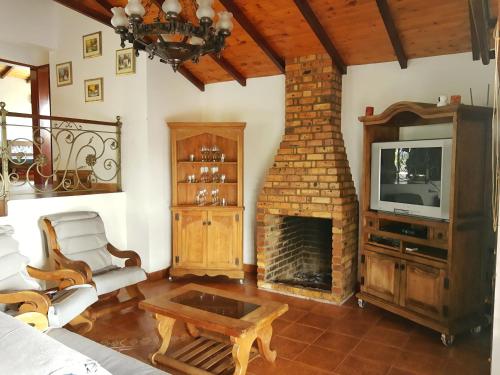 La GranjaCASA CAMPESTRE frente Acuarela -Mesa de los Santos的客厅设有壁炉和电视。