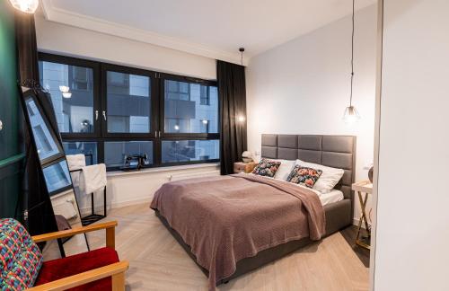 比得哥什E&A Royal Luxury Apartments, Bydgoszcz - SKYLINE的一间卧室设有一张床和一个大窗户